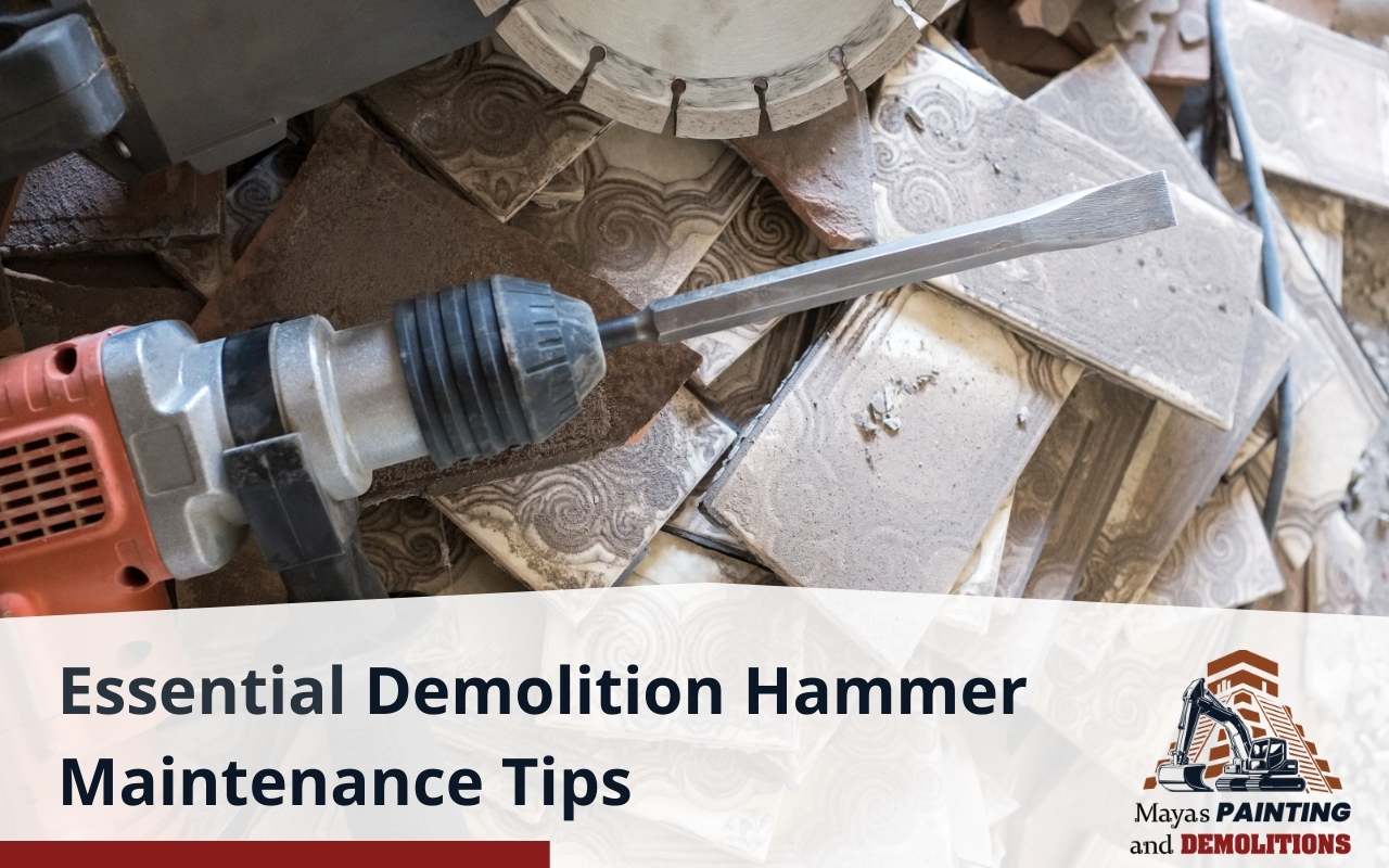A worker cleaning a demolition hammer after use to remove debris.