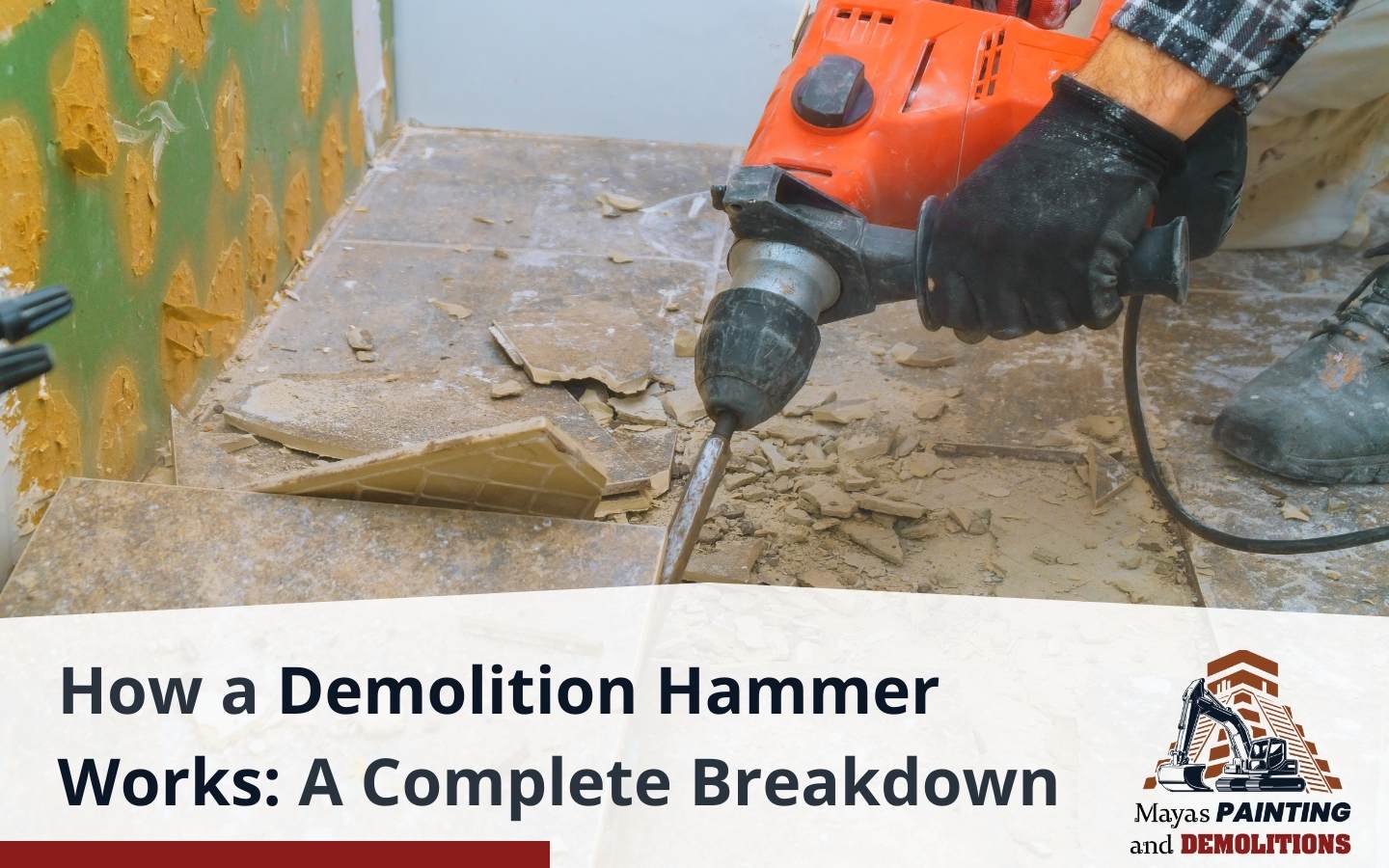 A worker using a demolition hammer to break a concrete floor.