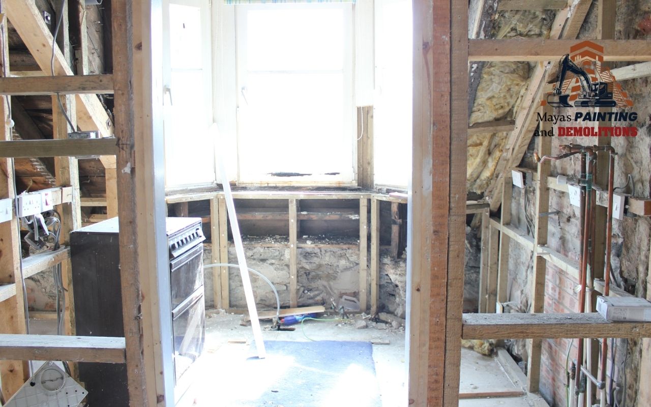 Appliances being removed from a kitchen before demolition starts.